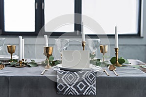 close up view of empty card on plates on tabletop with beautiful rustic setting for guests