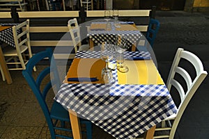 Close up view of empty quaint little restaurant with tables set on the sidewalk