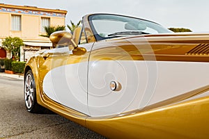 Close up view of exclusive vintage car is standing on narrow small streets, replica on the famous convertible car in