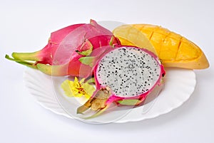 Close up view of exotic dragon fruit with mango cut and whole sliced isolated on white background with petals