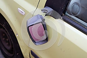 Close-up view of exterior broken vandalism side view mirror on old car