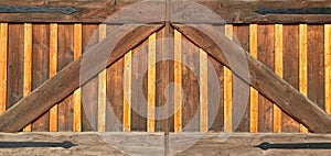 Close-up view of farm barn coral stable wooden wild west gate doors with wrought iron hinges