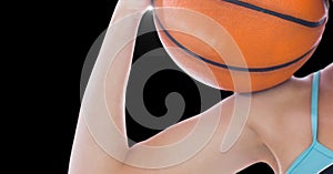 Close up view of female athlete holding a basketball against black background