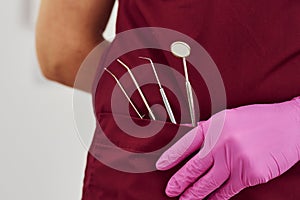 Close up view of female dentist in uniform that standing in stomatology office with tools in pocket