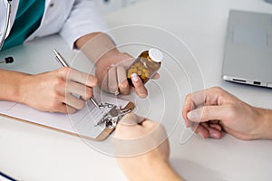 Close-up view of female doctor hand holding bottle with pills