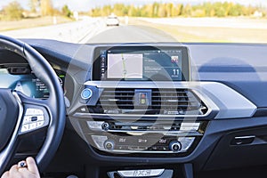 Close up view of female hands on steering wheel of electric car BMW iX3.