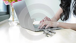 Close up view female hands typing on laptop, doing online job, emailing to client while sitting at office desk