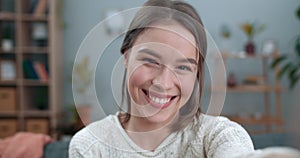 Close up view of female joyful person having video call and using frontal camera of smartphone. Woman smiling and saying