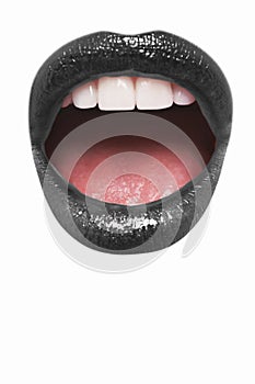 Close-up view of female wearing black lipstick with mouth open over white background