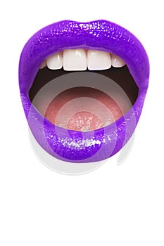 Close-up view of female wearing purple lipstick with mouth open over white background