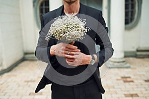 Close up view of fiance that holding flowers in hands
