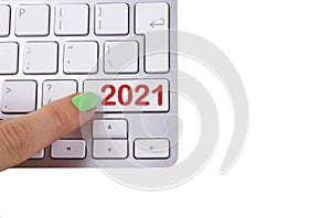 Close up view of a finger pushing on a red 2021 button of computer keyboard. Computer notebook keyboard with 2021 key.