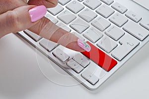 Close up view of a Finger Pushing on a red empty Button on computer Keyboard. Finger Pressing a Slim Aluminium Keyboard Button.
