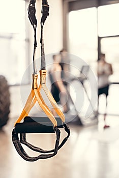 close-up view of fitness straps and young sportsmen standing behind