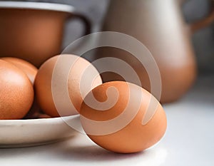 A close-up view of five brown eggs on a plate. Simplicity in nutrition - fresh brown eggs as a symbol of organic wholesomeness