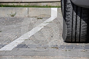 Close-up view flat rear tire on a car. Detail of car wheel flat tire on the road, parking lot. Burst tire background.