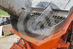 close up view of the flowing concrete from concrete mixer machin