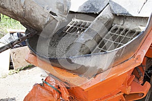 close up view of the flowing concrete from concrete mixer machin