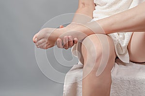 Close-up view of foot in female hands. Female legs. Reflexology. Self-massage of the feet