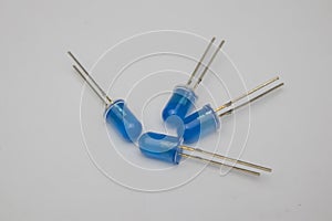 Close-up view of four blue LED (Light Emitting Diode) components on a gray background