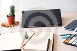 Close up view of freelancer workplace with blank screen tablet and empty notebook. Home office and distance learning