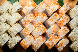 Close up view of fresh california sushi rolls set isolated on wooden background