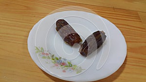 Close up view of fresh dried date palm served in ceramic small white plate