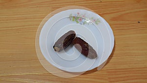Close up view of fresh dried date palm served in ceramic small white plate