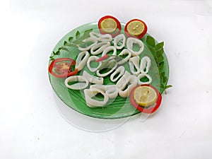 fresh whole cleaned Loligo Squid ring (Loligo Duvauceli) decorated with curry leaves , tomato,lemon slice and