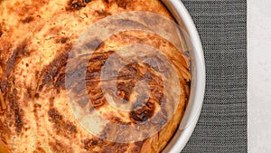 Close-up view of freshly baked phyllo dough pie with cream cheese filling, flat lay