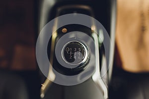 Close up view of a gear lever shift. Manual gearbox. Car interior details. Car transmission. Soft lighting. Abstract