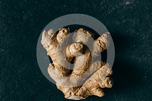 Close up view of ginger root on black slate background. Organic and healthy food.