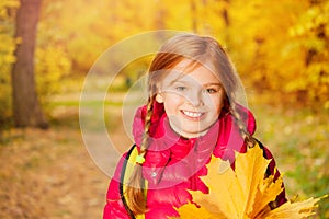 Close-up view of girl with rucksack and maple leaf