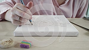 Close up view of girl`s hand drawing a picture with a pencil. Teenaged artist.