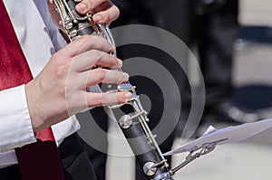 Close-up view of a girl`s hands playing the clarinet, music learning