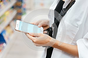 Close up view girl using smartphone in store.