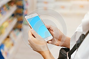 Close up view girl using smartphone in store.