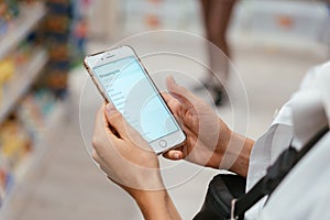 Close up view girl using smartphone in store.