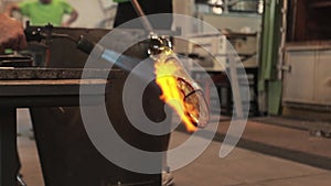 A close-up view of a glassblower's hands shaping molten glass into a delicate piece of art in Murano