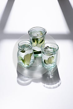 close up view of glasses with water, lime pieces and ice cubes