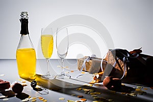 close up view of glassware with yellow champagne, macarons and arranged gifts