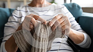 Close up view grandmothers hands holding needles and knitting