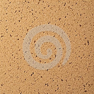 A close up view of a granular beige surface with a rough texture