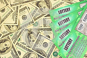 Close up view of green lottery scratch cards and us dollar bills. Many used fake instant lottery tickets with gambling results.