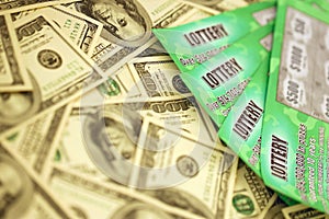 Close up view of green lottery scratch cards and us dollar bills. Many used fake instant lottery tickets with gambling results.