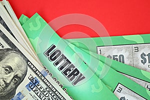 Close up view of green lottery scratch cards and us dollar bills. Many used fake instant lottery tickets with gambling results.