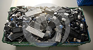 Recycling Bin Overflowing with Discarded Computer Keyboards and Mice