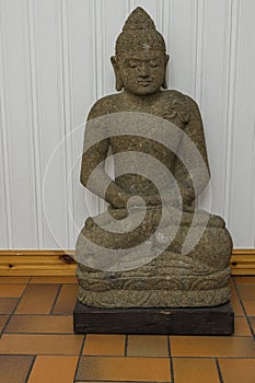 Close up view of grey buddah figure on white wall background