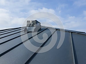 close up view of grey folding roof and chimney on waterproofing layer of house under construction