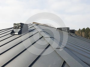 close up view of grey folding roof and chimney on waterproofing layer of house under construction